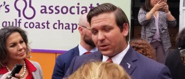 DeSantis talks with reporters after the bill signing