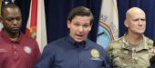 DeSantis in Orlando, flanked by state Sen. Randolph Bracy & Adj. Gen. James Eifert
