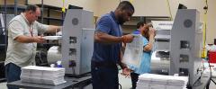 Election workers in Broward County feed ballots into machines